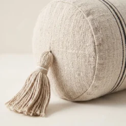 Close-up of cream striped bolster pillow tassel and woven texture