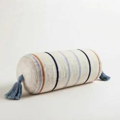 Cream multi stripe cylindrical bolster pillow cover with blue tassels on white background