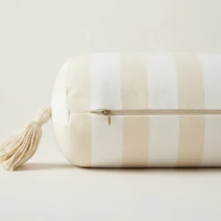 Close-up of cream and white striped bolster pillow with concealed zipper and tassel