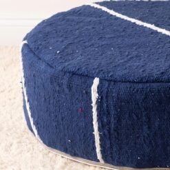 Close-up of deep blue cotton pouf showing an ivory stripe and textured woven surface