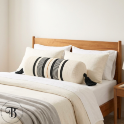 Handwoven striped Moroccan bolster pillow styled in a bright neutral bedroom