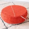 Orange round cotton pouf with fine ivory stitch lines
