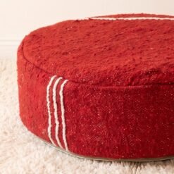 Close-up of red cotton pouf showing ivory stripes and textured weave